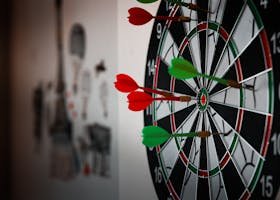 Close-up of a dartboard with multiple darts hitting the target, emphasizing precision and focus.