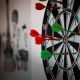 Close-up of a dartboard with multiple darts hitting the target, emphasizing precision and focus.